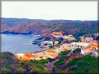 imagen de la calita de Es Murtar, con su costa negra por la piedra de pizarra negra que esta parte de la costa de Menorca