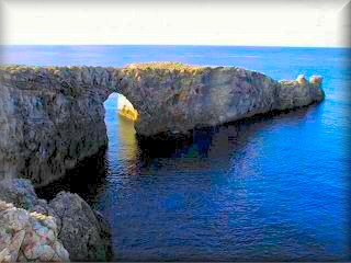 Blick auf das unberührte Gebiet von Pont d`en Gil (Gil-Brücke), ein Felsbogen, der durch die Erosion des Meeres in den Felsen der Küste ganz im Westen von Menorca entstanden ist